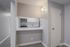 Modern kitchen nook with sleek countertops, integrated microwave, and ambient lighting in a cozy apartment setting.