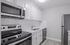 Modern kitchen with sleek stainless steel appliances, pristine white cabinetry, and elegant quartz countertops.