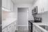 Modern kitchen with sleek white cabinetry, stainless steel appliances, and elegant countertops.