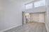 Bright and airy room with modern wood flooring, high ceilings, and large windows flooding the space with natural light.