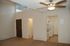 Inviting apartment interior with a cozy kitchen, elegant ceiling fan, and abundant natural light from high windows.