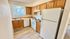 Charming, bright kitchen with warm wooden cabinets, modern appliances, and inviting laminate wood flooring, ideal for creating culinary delights.