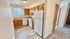 Charming kitchen with warm wooden cabinets, modern appliances, and sleek flooring, perfect for culinary adventures.