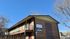 Charming newly remodeled brick apartment building with modern balcony and clear skies.