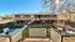 Inviting apartment building with sunlit courtyard, outdoor seating, and a charming landscape view.