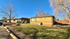 Charming brick ranch-style home with large front yard in a serene neighborhood setting, bathed in sunlight.