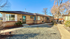 Charming single-story brick apartment with large windows, nestled in a serene, landscaped community.