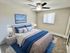 Inviting bedroom with stylish blue accents, modern decor, and a serene wall painting, perfect for relaxation.