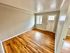 Inviting living room with rich hardwood floors and abundant natural light from large windows.