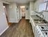 Modern kitchen with sleek countertops, stainless steel sink, and elegant cabinetry opening to a cozy bathroom.