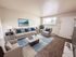 Inviting living room with a comfy sofa, modern decor, and large windows for natural light, perfect for relaxation.