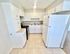 Bright, spacious kitchen with modern white cabinetry, sleek countertops, and large appliances, perfect for culinary enthusiasts.