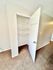 Bright closet space with open shelving, perfect for organized storage, in a well-lit room with plush carpeting.