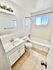 Bright and inviting bathroom featuring a sleek bathtub, modern vanity, and natural light from the window.