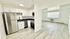 Bright and modern open-concept kitchen and living space with sleek stainless steel appliances and elegant light wood flooring.