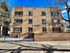 Charming three-story brick apartment building with large windows and a secure gated entrance, offering a welcoming and safe living environment.