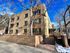 Charming brick apartment building under a vibrant blue sky, featuring gated entry and inviting surroundings at The Birney.