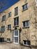 Charming brick apartment building with vintage architectural details and welcoming entrance, offering a cozy urban living experience.