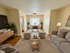 Elegant open-concept living room with cozy seating, stylish decor, and natural light flowing from large windows, perfect for entertaining.
