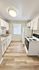 Bright kitchen with modern white cabinets, sleek appliances, and wood-style flooring, perfect for culinary creativity.