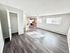 Chic and spacious open-plan apartment with elegant dark wood flooring, modern kitchen, and abundant natural light.