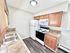 Modern kitchen with elegant wooden cabinets, tile countertops, and essential appliances for a cozy cooking experience.