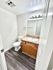 Bright and modern bathroom with sleek dark flooring, elegant vanity, and contemporary lighting.