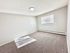 Bright and spacious bedroom with soft carpet flooring and natural light streaming through a large window, creating a warm and inviting atmosphere.