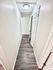 Bright, modern hallway with sleek laminate flooring and crisp white doors, offering a welcoming entryway.