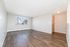 Bright and spacious living area with sleek hardwood floors and large window offering scenic views.