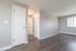 Bright and airy living space with modern gray flooring, soft gray walls, and a large window for ample natural light.