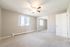 Bright and airy bedroom featuring plush carpeting, large window with natural light, and a mirrored closet for added elegance.