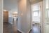 Inviting apartment interior featuring a modern kitchen with wood cabinetry, sleek hardwood floors, and a bright bathroom with natural light.