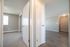 Modern apartment hallway featuring elegant wooden flooring, bright natural light, and doors leading to spacious rooms.