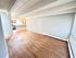 Bright, open-concept living space with elegant wood flooring and modern kitchen access, perfect for entertaining.