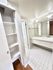 Bright and spacious bathroom with modern white tiles, generous shelving, and elegant fixtures.