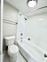 Elegant and modern bathroom featuring a pristine white bathtub, sleek fixtures, and contemporary lighting.