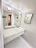 Modern bathroom vanity featuring a sleek rectangular sink, large mirror, and elegant wall lighting, perfect for a contemporary apartment.