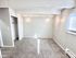 Bright, cozy room with plush carpet, textured ceiling, and natural light from a large window, featuring a built-in closet.