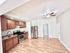 Bright, open kitchen with rich wooden cabinets, stainless steel appliances, and sleek hardwood flooring.