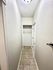 Bright, inviting hallway featuring elegant tile flooring and a modern light fixture, leading to a convenient closet space.