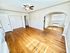 Bright, airy living room with beautiful hardwood floors and a classic arched doorway, perfect for modern living.