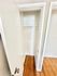 Bright and spacious closet with elegant wooden flooring, highlighting ample storage space in a modern apartment.