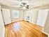Bright and airy room with polished hardwood floors, ceiling fan, and ample natural light, perfect for comfortable living.