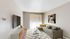 Chic living room with contemporary decor, featuring a plush gray sofa, vibrant yellow accents, and a stylish wall art centerpiece.