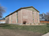 Charming brick apartment building with well-manicured lawn and serene residential surroundings, perfect for comfortable living.