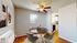 Charming dining area with modern round table and stylish chairs, adjacent to a cozy kitchen in a sunlit apartment.