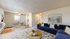 Inviting living room with a modern blue sofa, decorative pillows, and a chic round coffee table; adjacent to a cozy dining area with a ceiling fan and elegant table set, showcasing open-concept comfort.