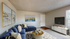 Bright and inviting living room with a plush blue sectional sofa, modern art pieces, and a sleek entertainment center under natural light.
