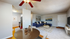 Inviting open-plan living area featuring a chic round dining table, modern kitchen, cozy navy sofa, and stylish decor accents.